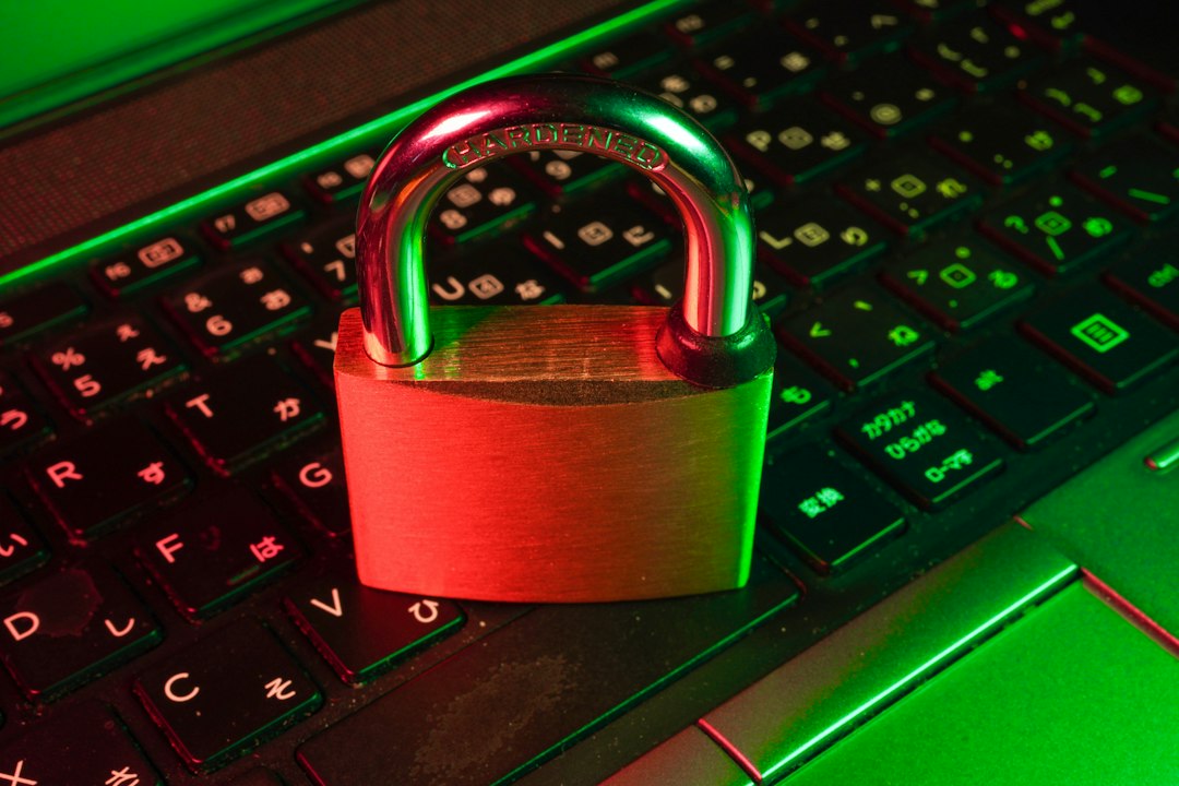 Padlock resting on a laptop keyboard with red and green lighting, symbolizing cybersecurity.