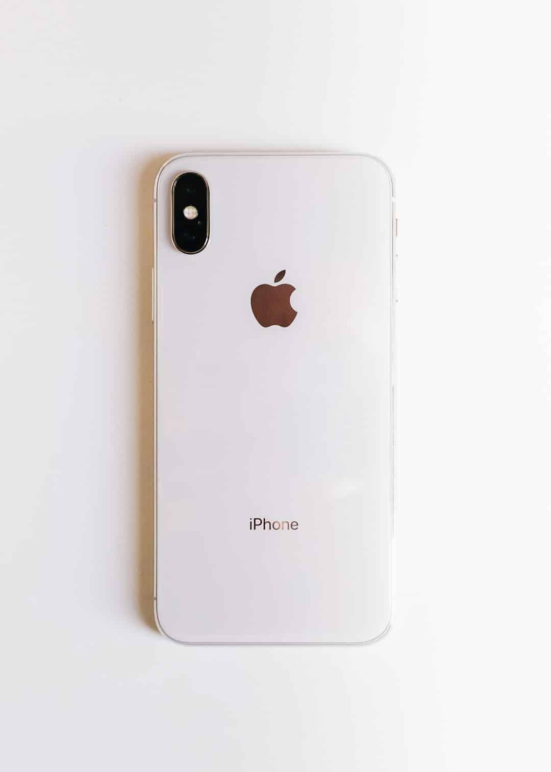White iPhone seen from the back, showing Apple logo and dual-camera bump at top-left with rounded edges.