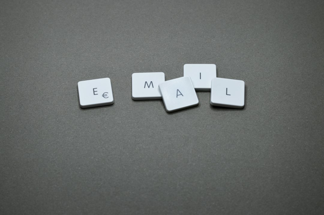 Tiles spell 'EMAIL' on a gray surface using white square letter tiles with black letters and a euro symbol on the first tile?