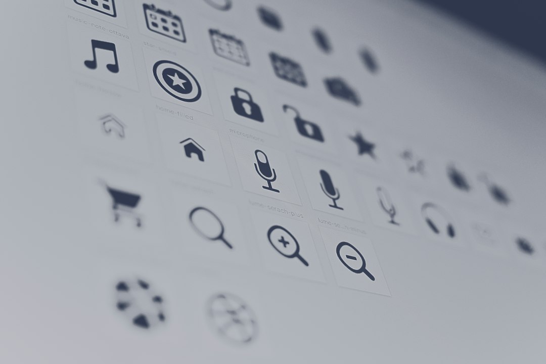 Blurred grid of app icons on a computer screen, including a microphone, search icons, calendar, and lock.