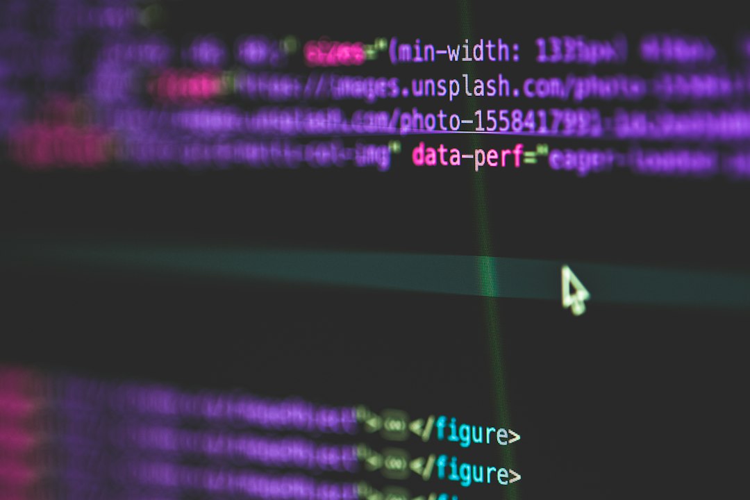 Close-up of colorful programming code on a dark screen with a white cursor nearby.