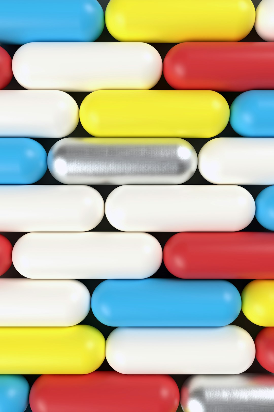 Close-up of a grid-like arrangement of colorful capsule pills in blue, yellow, white, red and silver tones filling the frame.