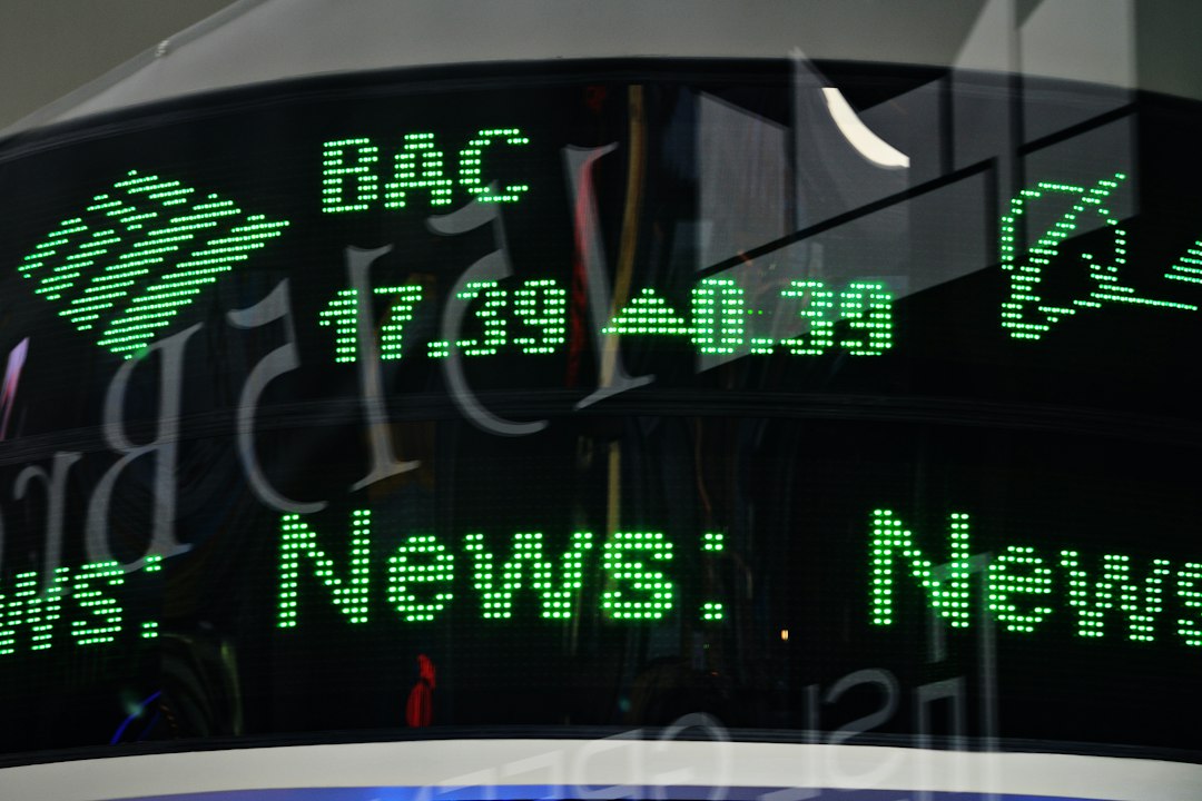 Close-up of a green LED ticker displaying 'News' and financial numbers on a glass surface.