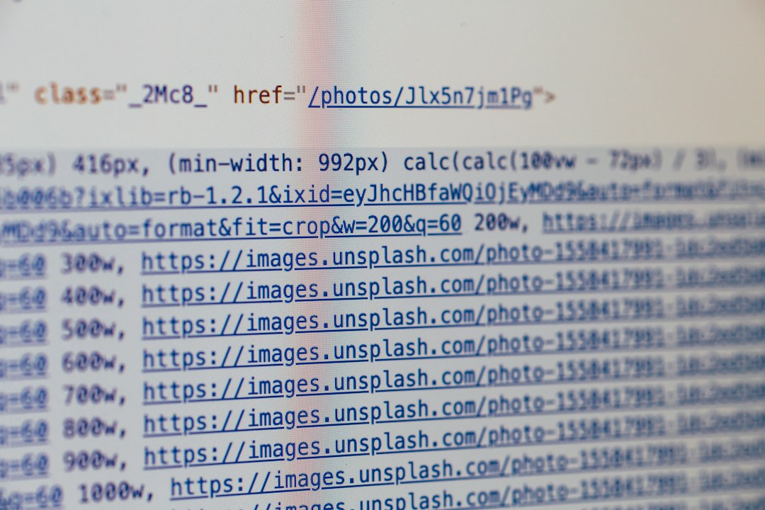 Close-up of a computer screen showing code with blue hyperlink URLs to images (Unsplash).