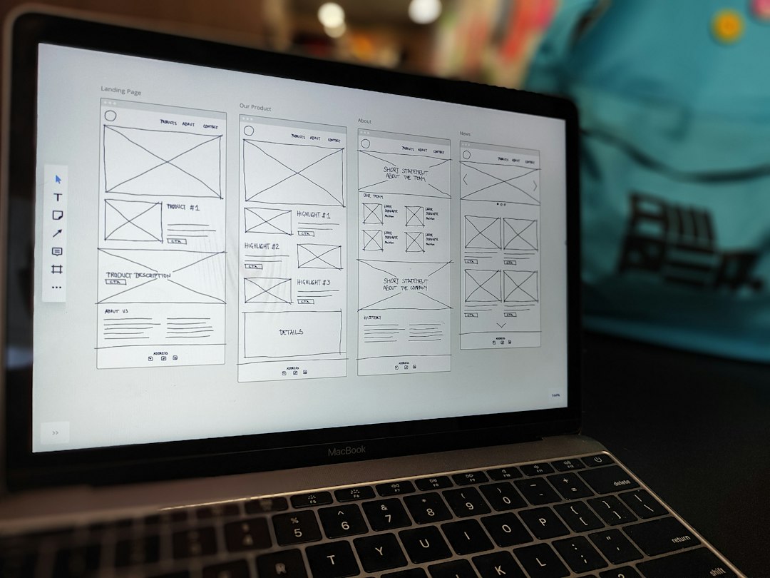Open MacBook displaying a grid of hand-drawn website wireframes on the screen, showing four columns labeled Landing Page, Our Product, About, News.