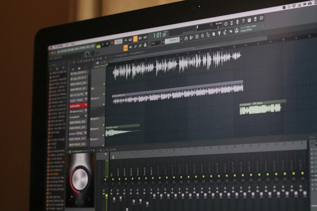 Screen displaying a digital audio workstation with multiple waveform tracks and a mixer panel behind it.