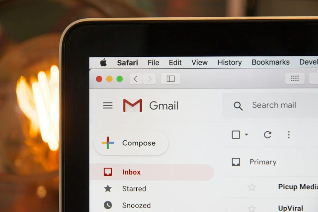 Laptop screen displaying Gmail with Inbox highlighted and Compose button visible in a Safari window