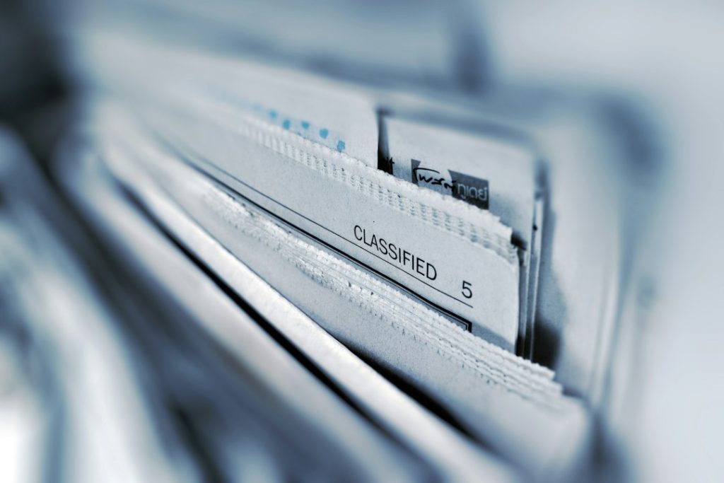 Stack of manila folders in a filing drawer labeled 'CLASSIFIED'.