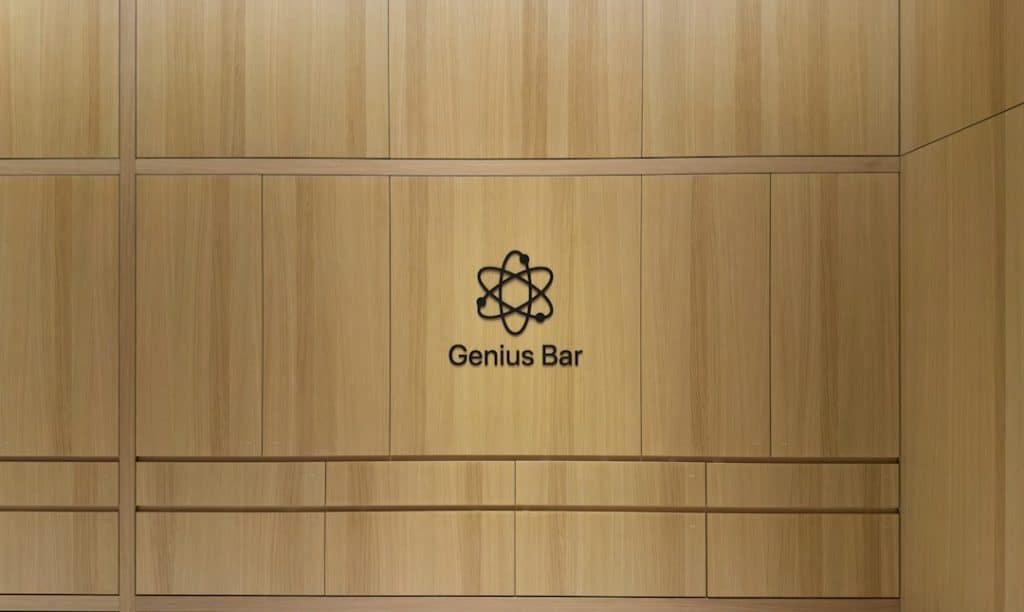 Wood-paneled wall with a black Genius Bar logo and the words ‘Genius Bar’ beneath it.