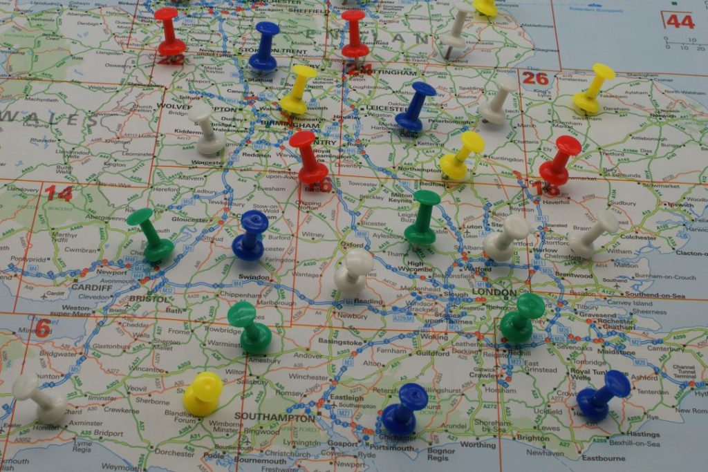 Colorful pushpins mark various locations on a detailed map of southern England around London.