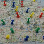 Colorful pushpins mark various locations on a detailed map of southern England around London.