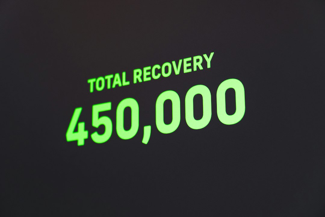 Neon-green text on a dark background reading 'TOTAL RECOVERY' with the number 450,000, tilted at an angle